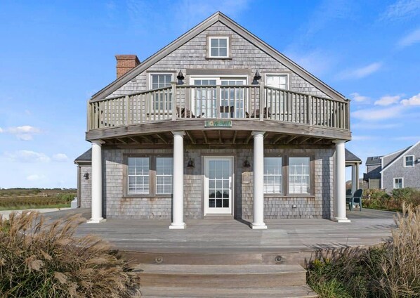 A two-story house with a balcony, a front porch with columns, and a sign that reads 'LIVE SWIM'.