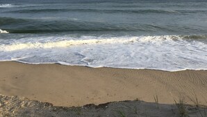 A beach with waves approaching the shore.
