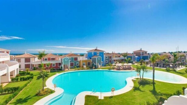 Un quartier r ésidentiel doté d’une grande piscine, entourée de maisons et de verdure.
