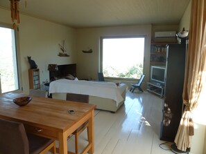 Ein Schlafzimmer mit einem Bett, einem Fernseher, einem Bücherregal und einem Fenster.
