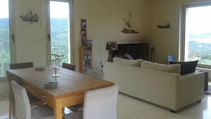 Una sala de estar con una mesa de comedor de madera, un sofá blanco y una chimenea.