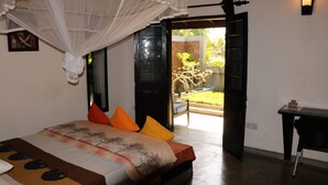 A bedroom with a bed, a desk, and a view of the outside. - Whispering Ocean (Panadura)
