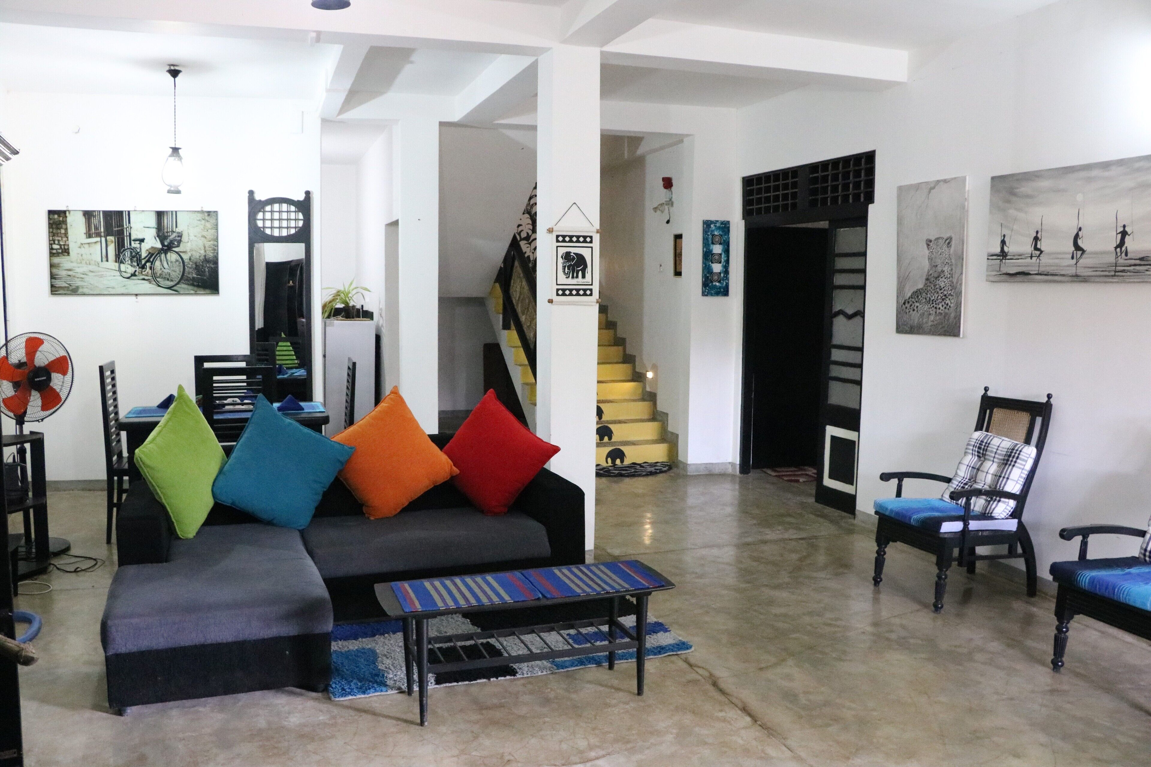 Ein Wohnzimmer mit einer Couch, Sesseln und einer Treppe.
