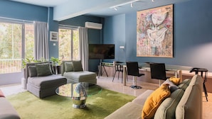 Ett vardagsrum med en soffa, fåtöljer, ett soffbord och en tv.