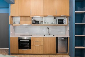 A modern kitchen with wooden cabinets, a built-in oven, a microwave, and a dishwasher. - Central Comfy Apt with Private Balcony & Rooftop Access. CT3 (Athens)