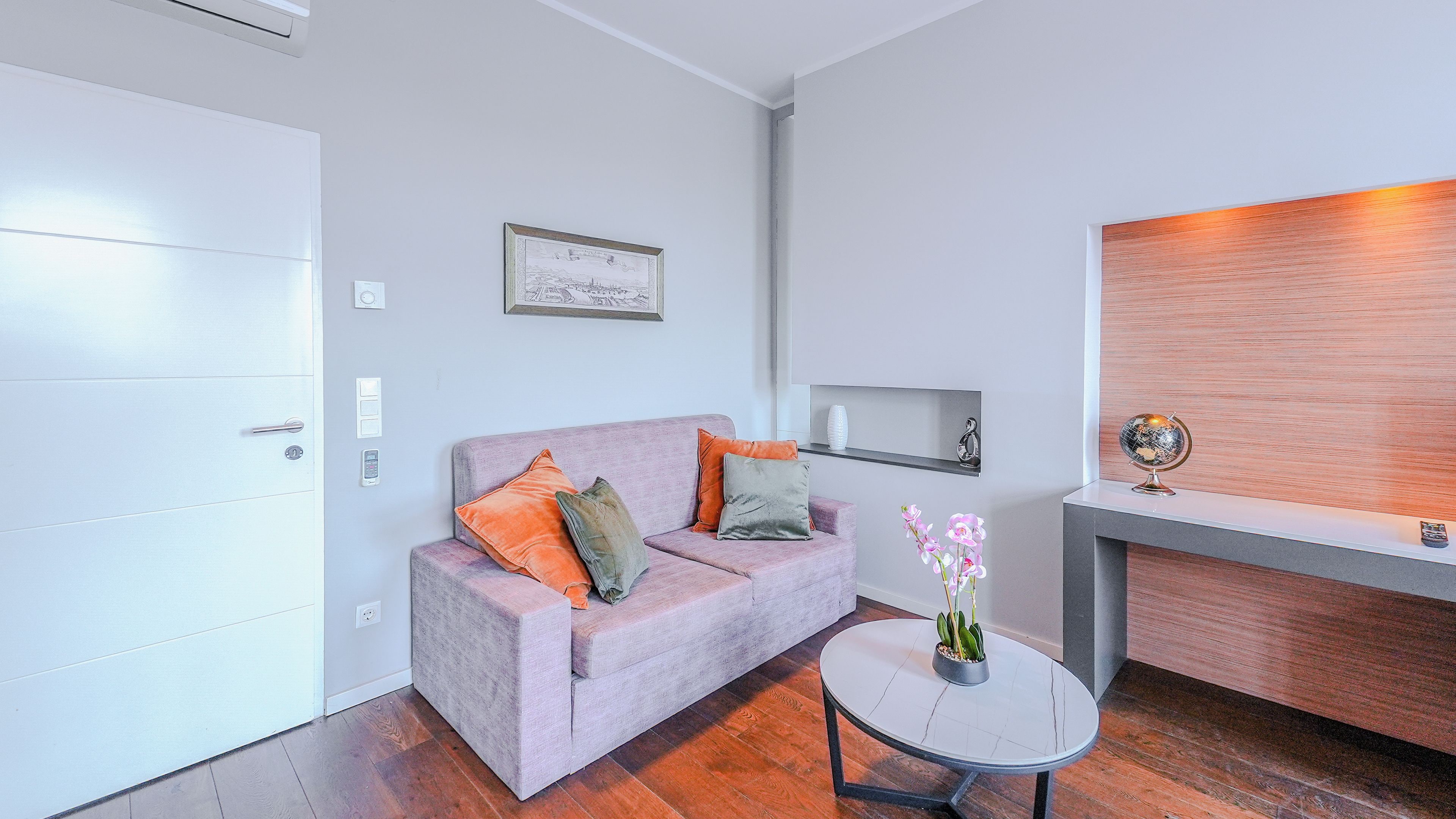 En moderne stue med en sofa, et lille bord og en dekorativ globus.