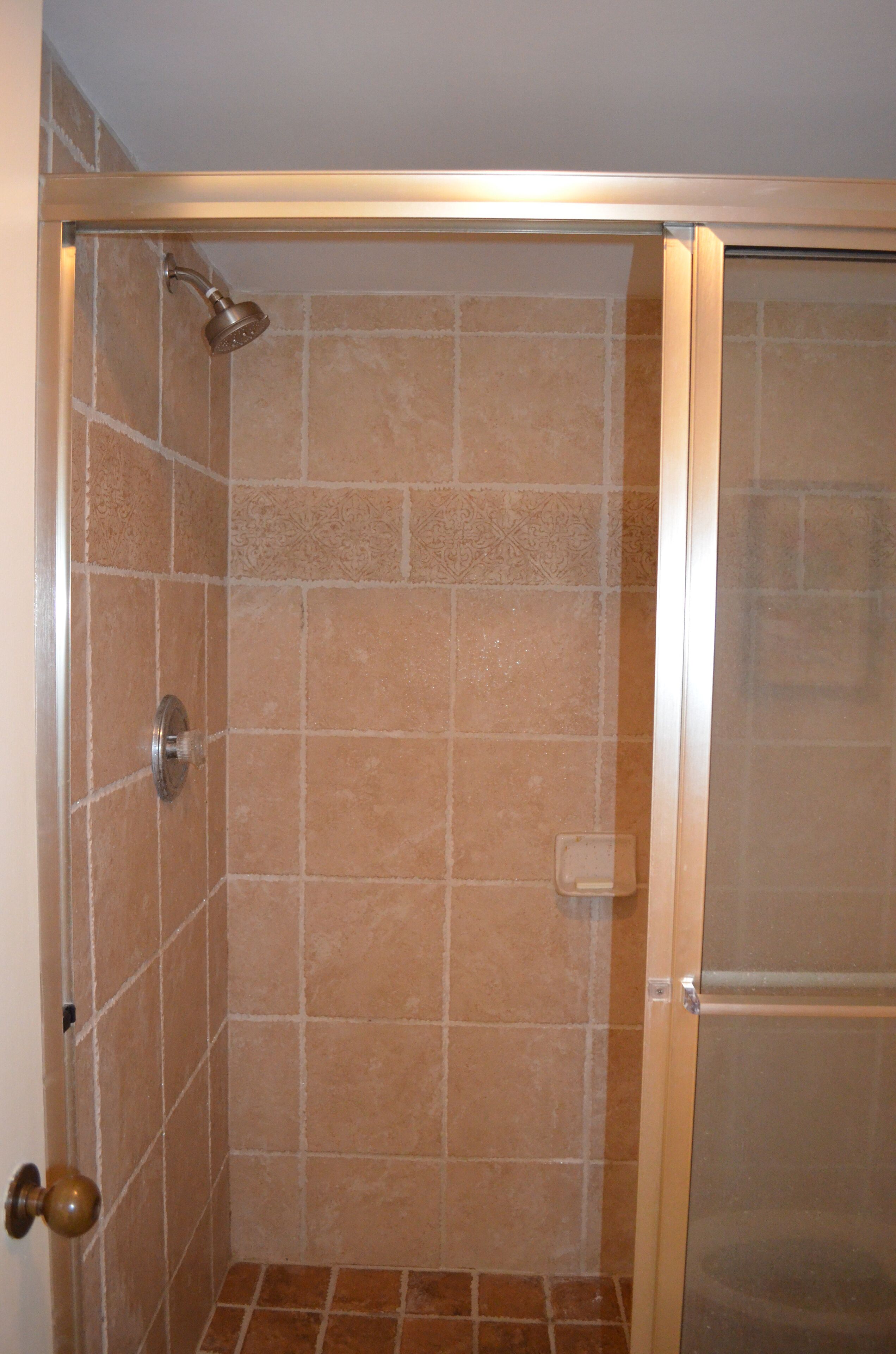 A shower with a glass door and a showerhead.