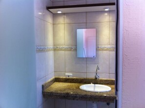 A bathroom with a granite countertop sink, a mirror, and tiled walls. - Pousada Requinte da Mantiqueira (Piracaia)