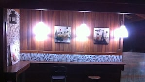 A bar area with wooden paneling, a tiled backsplash, and two stools. - Pousada Requinte da Mantiqueira (Piracaia)