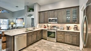 A modern kitchen with a central island, stainless steel appliances, and wooden cabinetry.