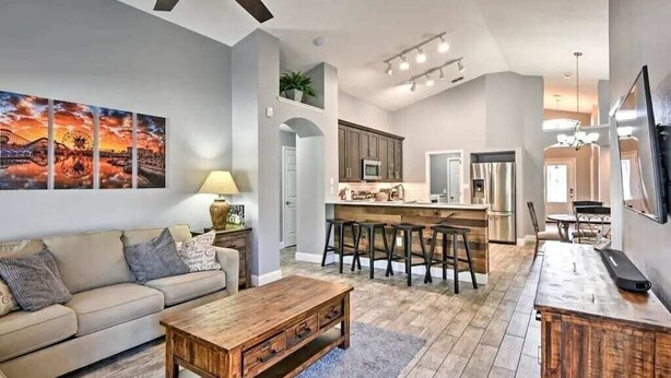 A spacious living area with a sofa, coffee table, and a kitchen in the background.