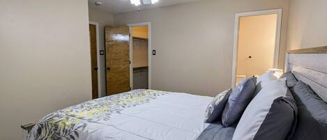 Un dormitorio con cama, ventilador de techo y puerta que da a un armario.
