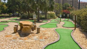 A miniature golf course with numbered holes and a stone centerpiece. - Tides at Tops`l #301- Overlooks the Gulf! (Miramar)