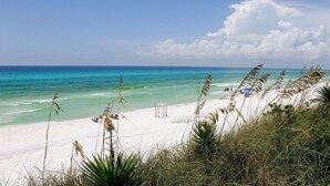A beach with white sand, clear turquoise water, and sparse vegetation. - Tides at Tops`l #301- Overlooks the Gulf! (Miramar)