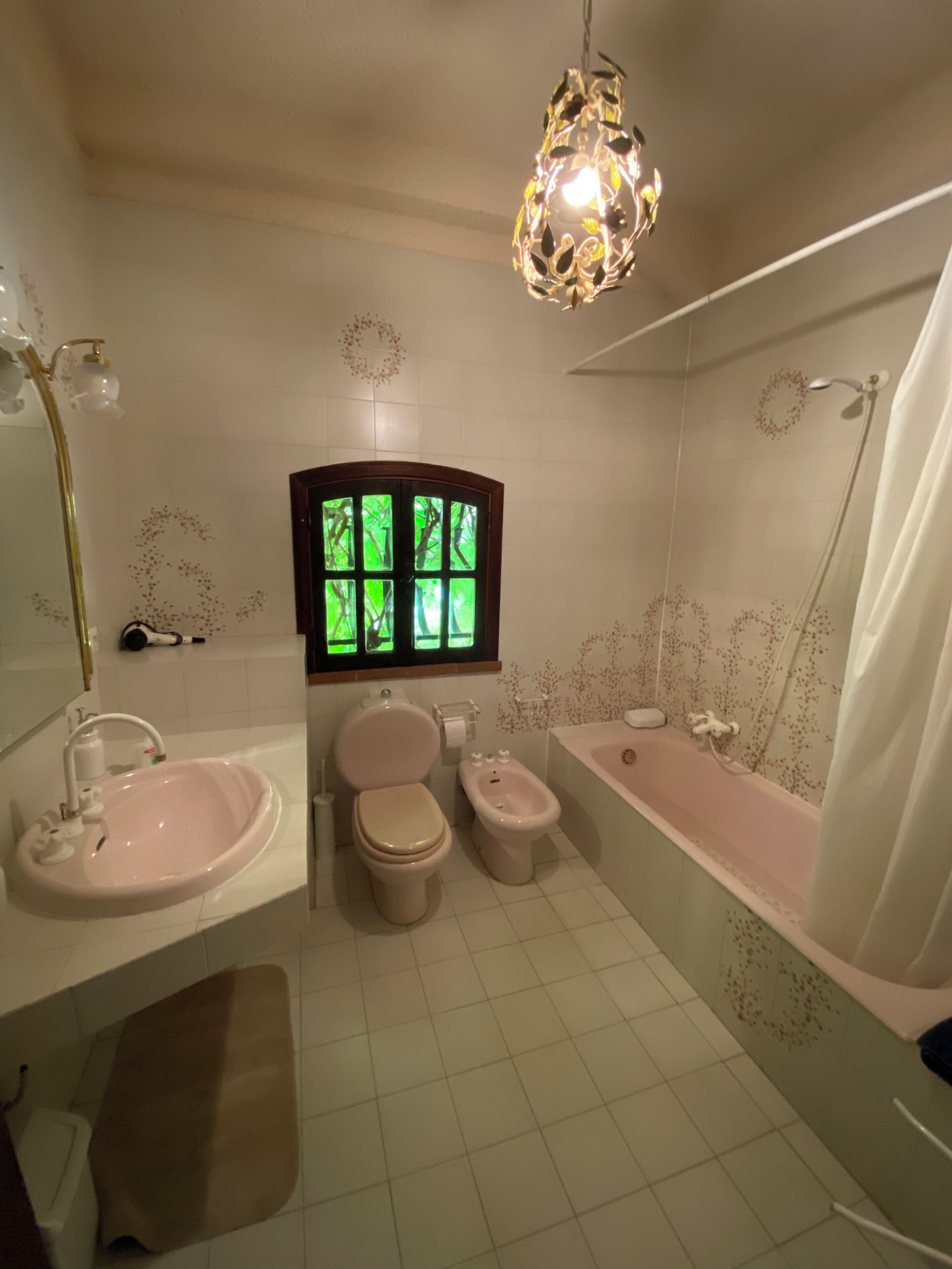 A bathroom with a sink, toilet, bidet, and bathtub.