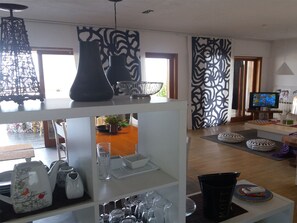 A modern living room with a TV, sofa, and decorative items on shelves. - Villa Barbara A show every dawn (giardini naxos)