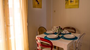 Een eettafel, gedekt met borden, glazen en bestek, omringd door stoelen.