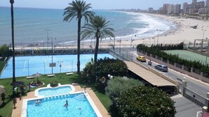 A pool area with a view of the beach and ocean. - seafront apartment with panoramic view to the ocean (El Campello, Alicante)