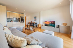 A modern living room with a sofa, a coffee table, and a TV. - Penthouse Rosas with Private Jacuzzi & Pool overlooking the Mountains (Puerto Pollensa)