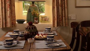 A dining table set with blue and white patterned dishes, a lamp, and a vase with flowers. - Thatched Irish Cottage in Beautiful and Tranquil Countryside (Limerick)