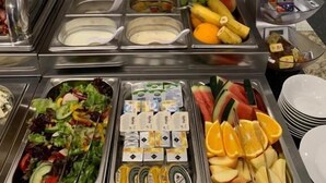 Un buffet con diverse opzioni tra cui frutta, insalate e latticini.