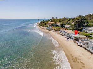 A coastal hotel with beachfront rooms, a sandy beach, and ocean views.