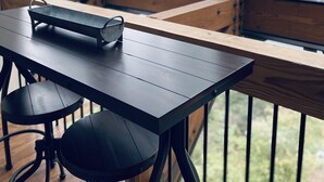 A wooden table with a metal tray, two chairs, and a view of a forest through large windows. - Panoramic Coeur D'Alene Lake View - 5 Minutes to Town (Coeur D Alene)