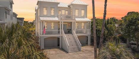 A multi-story house with a central staircase, a front porch, and a garage.