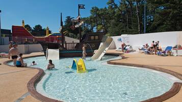 A swimming pool area with slides and a pirate-themed play structure.