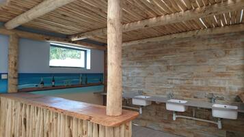 A wooden interior with a long counter and multiple sinks.