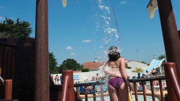 A water play area with a wooden structure and a person in a swimsuit.