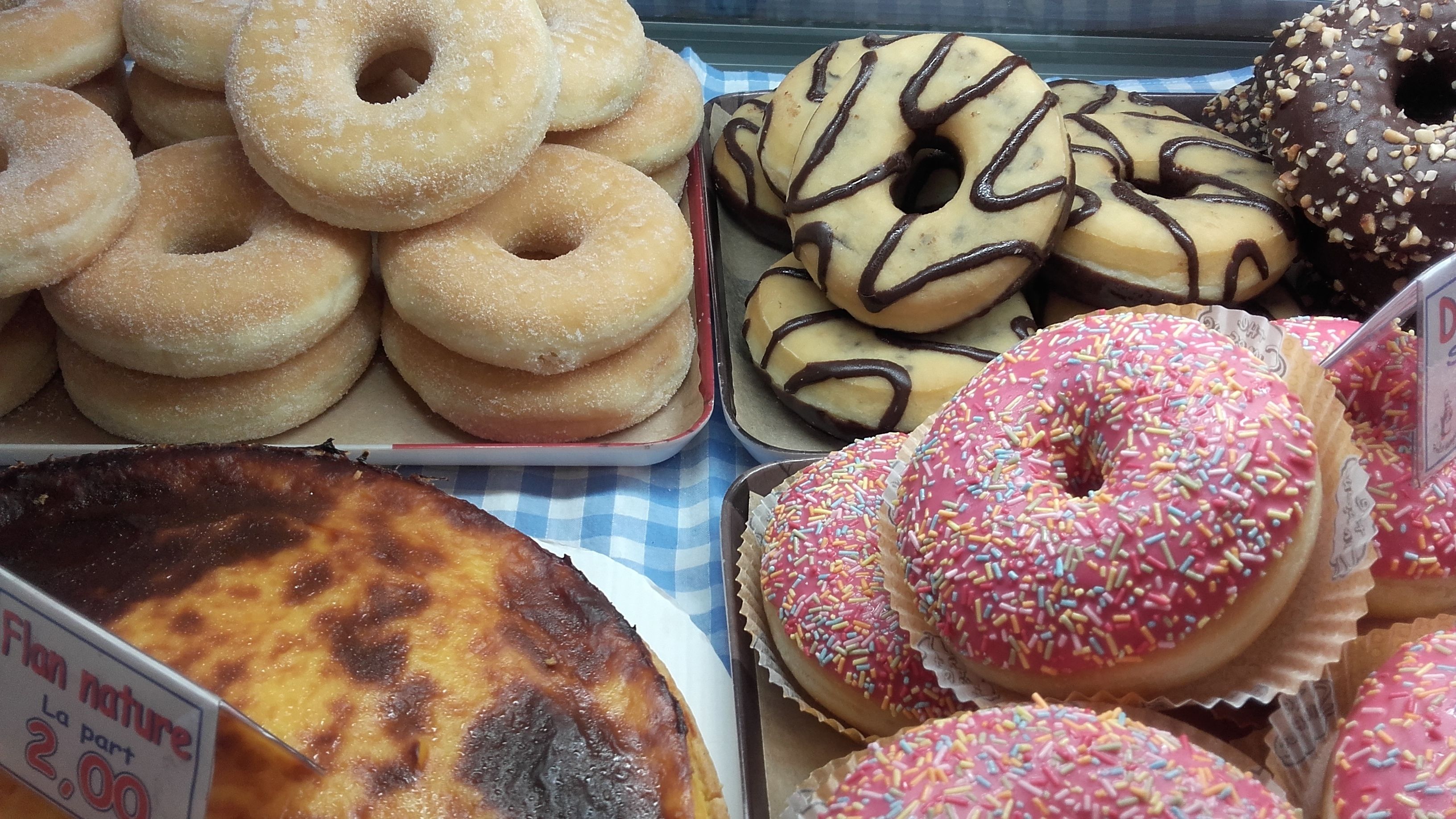 A variety of donuts displayed in trays.