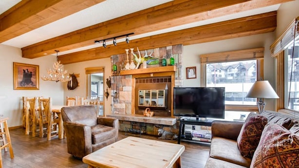 Ein gemütliches Wohnzimmer mit Holzmöbeln, einem Kamin und einem Fernseher.