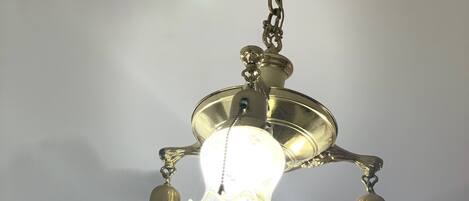Techo con un diseño ornamentado y una araña con tres lámparas.