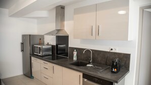 A modern kitchen with stainless steel appliances, a dishwasher, and a coffee maker. - Furnished with charm in the Drôme Provençale (La Bégude-de-Mazenc)