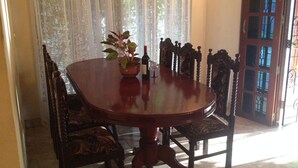 Une table à manger avec des chaises, une plante en pot et une bouteille de vin.