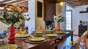 A dining area with a long wooden table set for a meal, featuring woven placemats and clear glassware. - Provencal farmhouse in central Provence (Caumont-Sur-Durance)