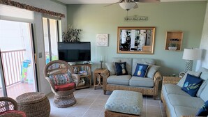 Un salon avec des meubles en osier, un téléviseur et une pancarte indiquant « Hilton Head Island ».