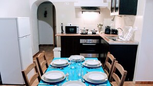Comedor con mantel azul, platos blancos y cubiertos para seis comensales.