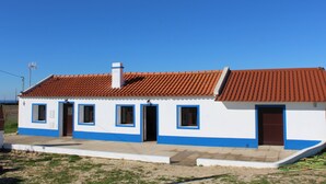Un edificio de una planta con tejado de tejas rojas y detalles azules.