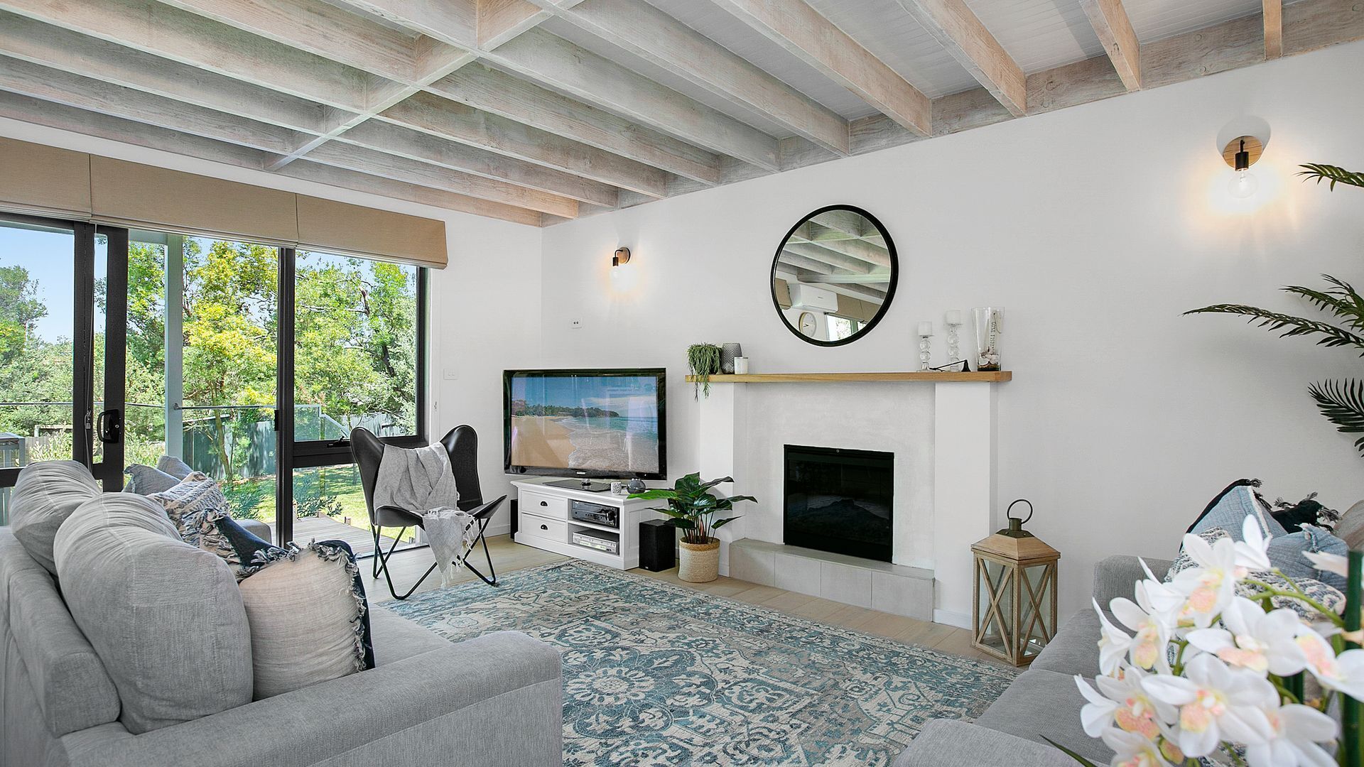 Una sala de estar moderna con televisión, sofá y chimenea.