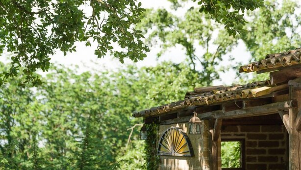 A rustic outdoor seating area with stone walls and a wooden pergola. - Il Rifugio Pecorella (Alvignano)