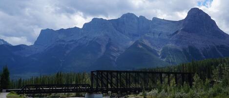 A bridge over a river with mountains in the background.