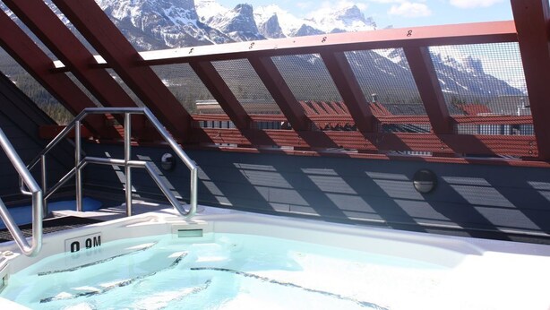 A swimming pool with a view of snow-capped mountains. - Boutique mountain condo with BREATH-TAKING views in the heart of it all! (Canmore)