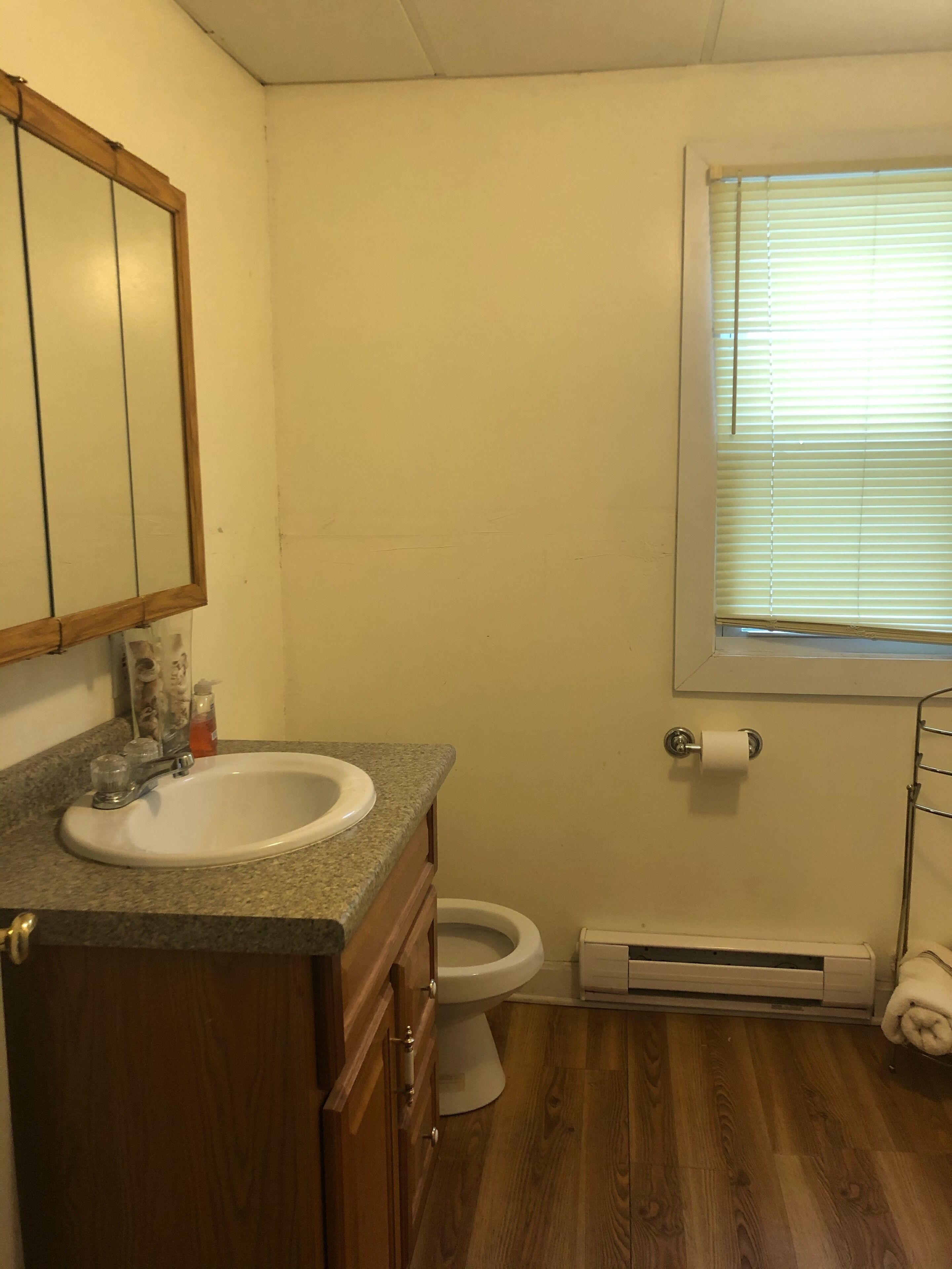 Un baño pequeño con lavamanos, inodoro y ventana.