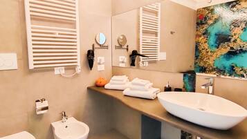A modern bathroom with a bidet, toilet, and a large sink.