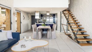 Un intérieur moderne comprenant un coin repas, une cuisine et un escalier.