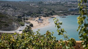 Une ville côtière avec une plage, des bâtiments et une route.
