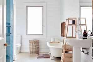 Bathtub, hair dryer, towels, toilet paper