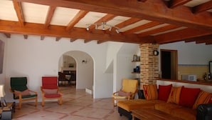 A spacious living area with a high wooden ceiling, a brick fireplace, and a cozy seating arrangement including a sofa and chairs. - Large luxury Villa located in beautiful countryside close to shops (Saint Ciers du Taillon)